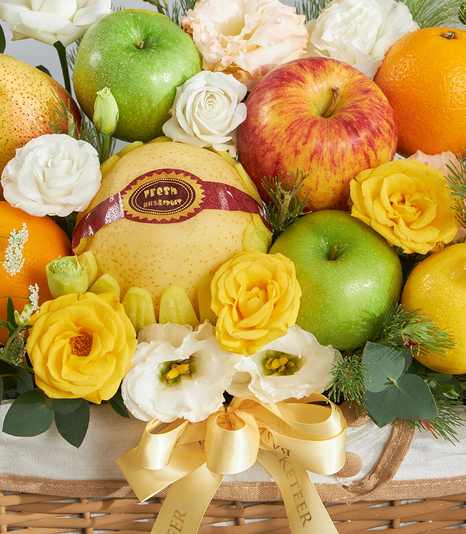Premium fruit and flower gift basket with yellow roses, white eustoma, fresh apples and pears in woven wicker