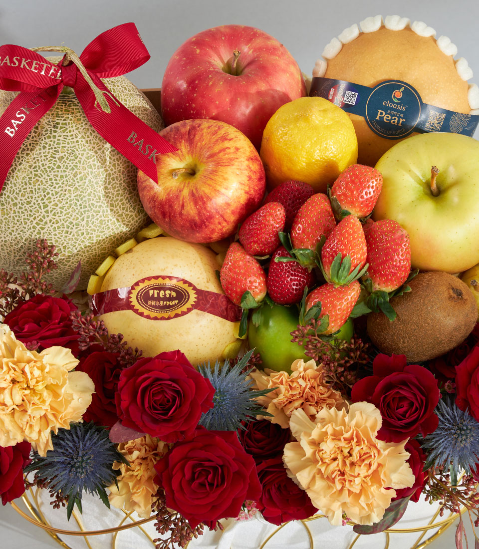 Luxury red and gold fruit floral basket with fresh cantaloupe, apples, strawberries, and deep red roses for birthdays