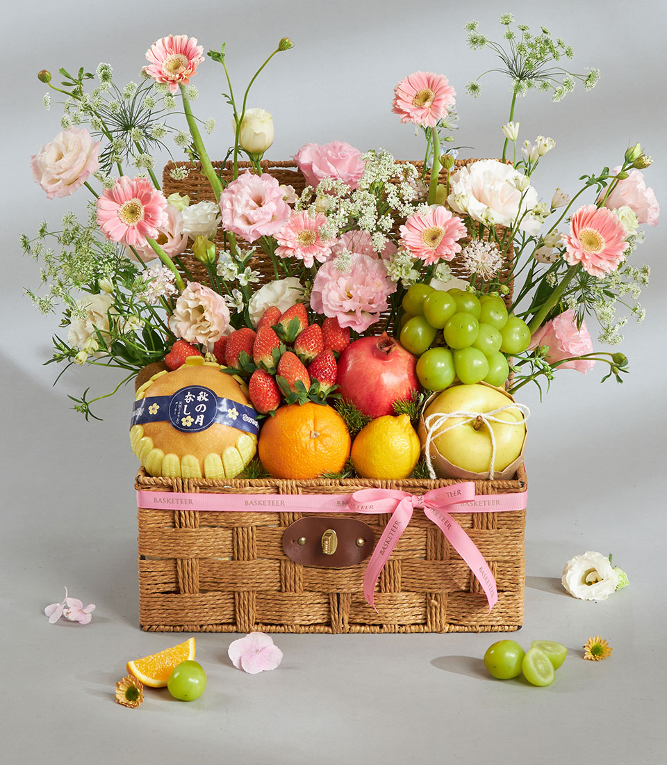 Premium pink and white fruit and floral gift basket with fresh pears, strawberries, pomegranate, citrus, and artisan blooms