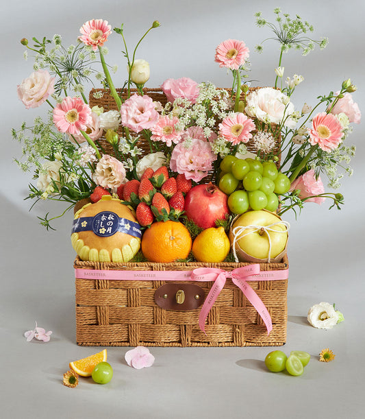 Premium pink and white fruit and floral gift basket with fresh pears, strawberries, pomegranate, citrus, and artisan blooms