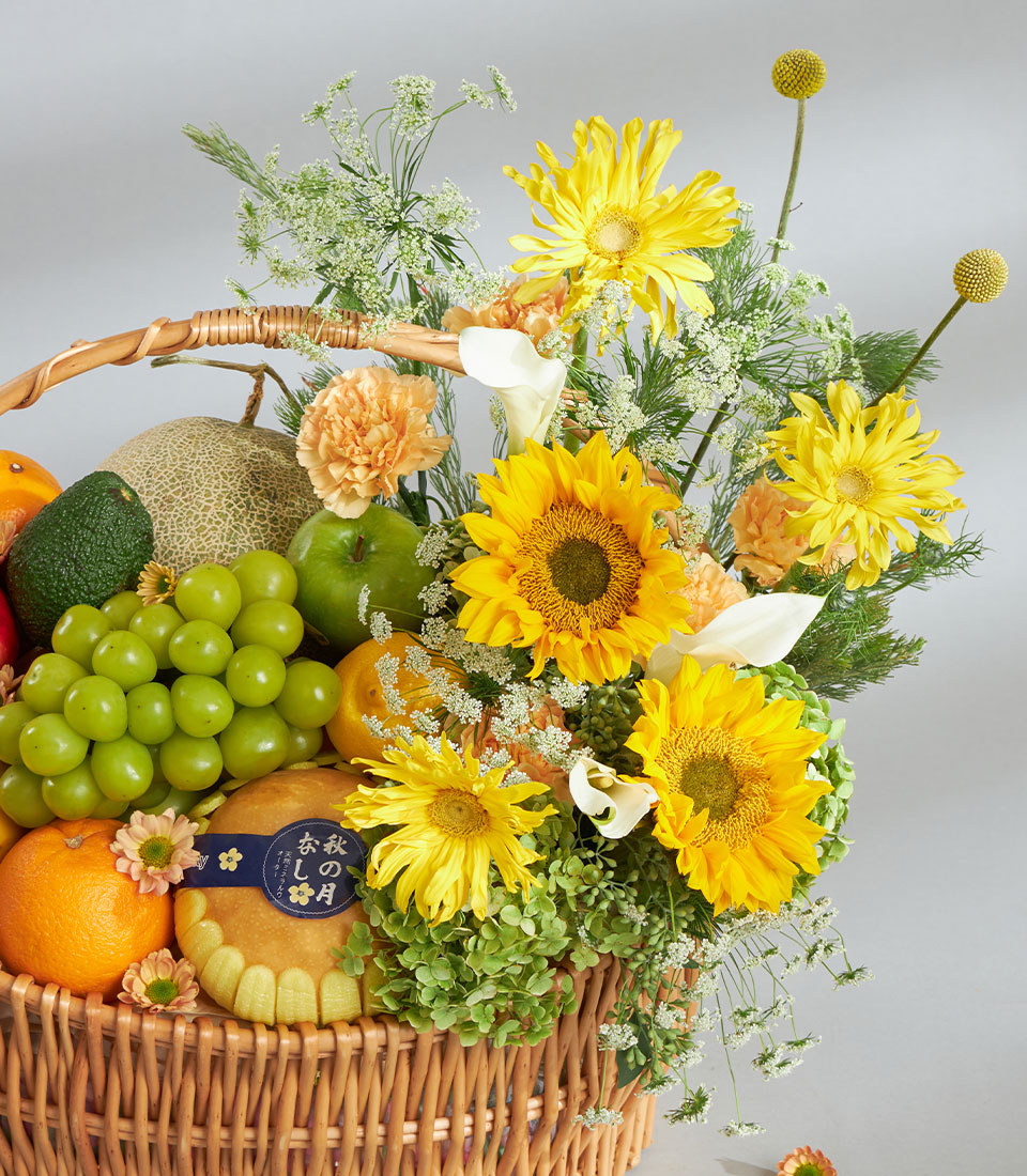 Bright yellow sunflower and fresh fruit luxury gift basket with artisan baked good and woven wicker presentation