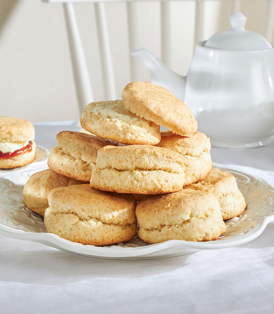 Golden British scones with jam and cream, traditional afternoon tea baked goods