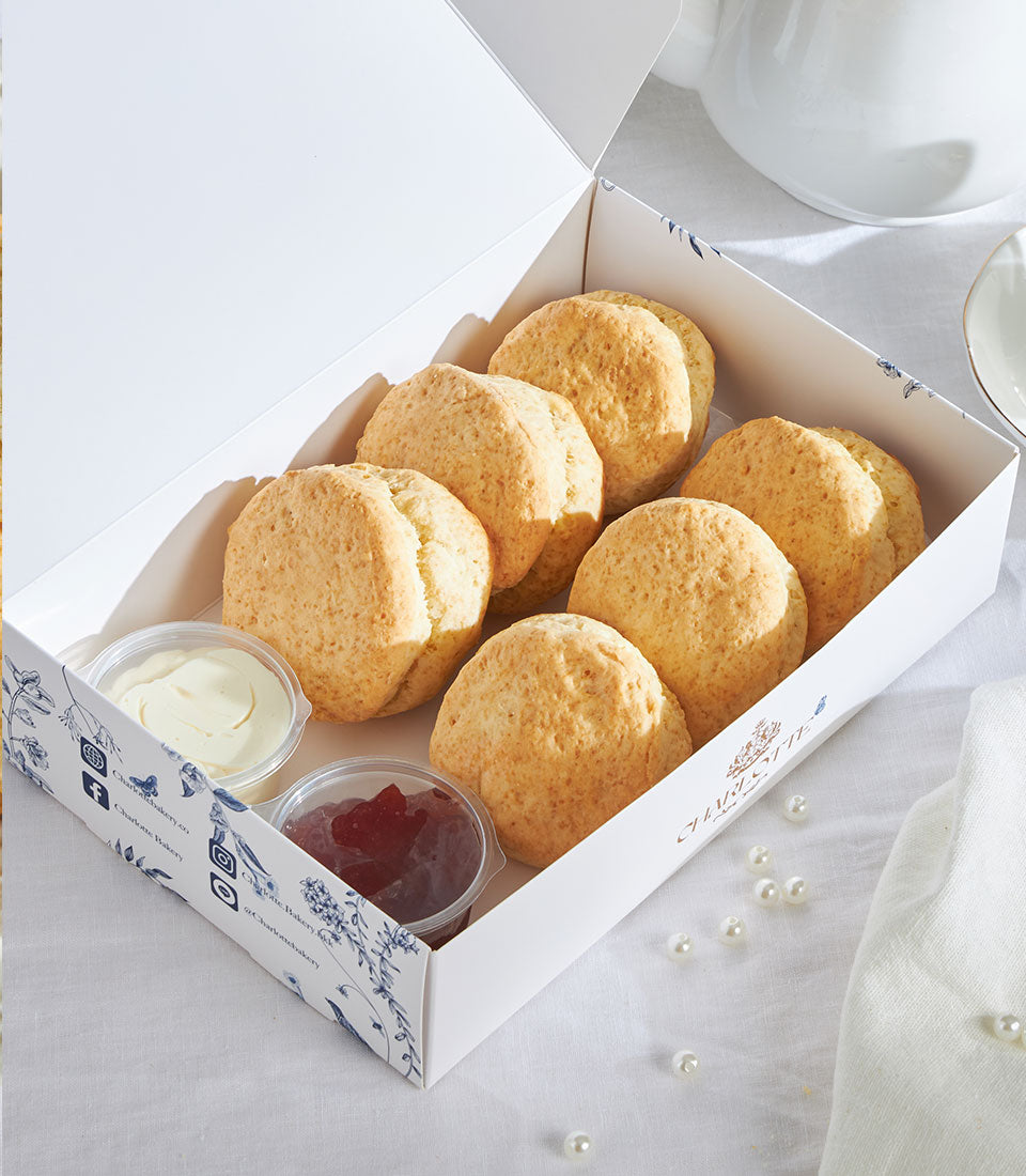 Golden British scones with clotted cream and jam in luxury gift box