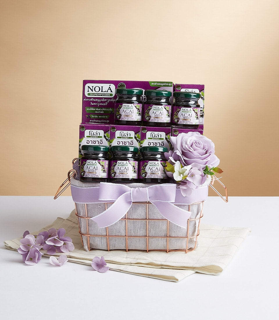 Rose gold mesh gift basket with Nola acai berry preserves, purple and white flowers, grey linen liner