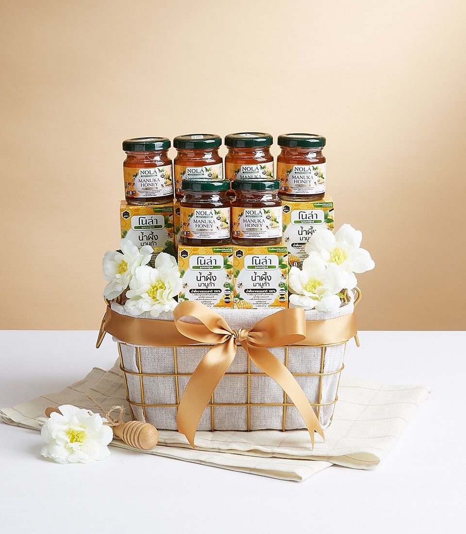 Nola Superfood gift basket with raw honey jars, golden ribbon, and artisan wellness gifting