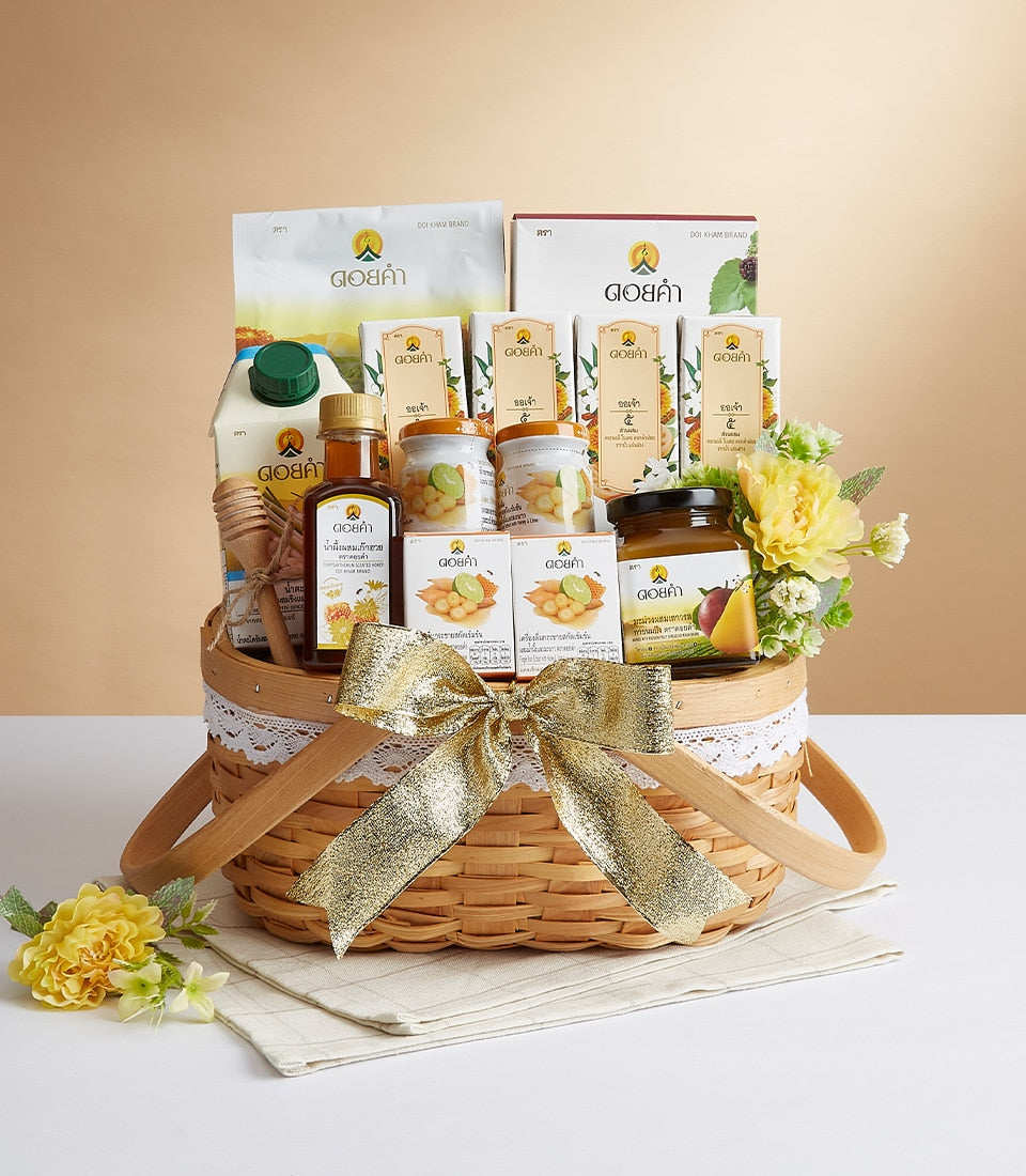 Light brown woven gift basket with gold bow, filled with gourmet health and wellness products including honey, preserves,