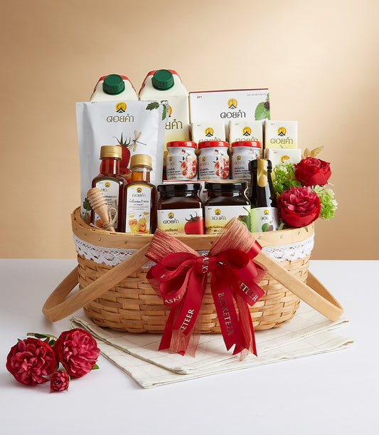 Woven gift basket with Doi Kham premium highlands food selection, honey, and artisan jars tied with red Basketeer ribbon