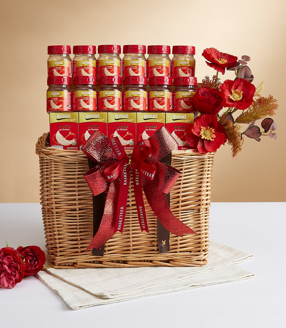 Luxury gift basket with bird's nest jars, premium boxes, and red poppies in woven wicker with leather handles
