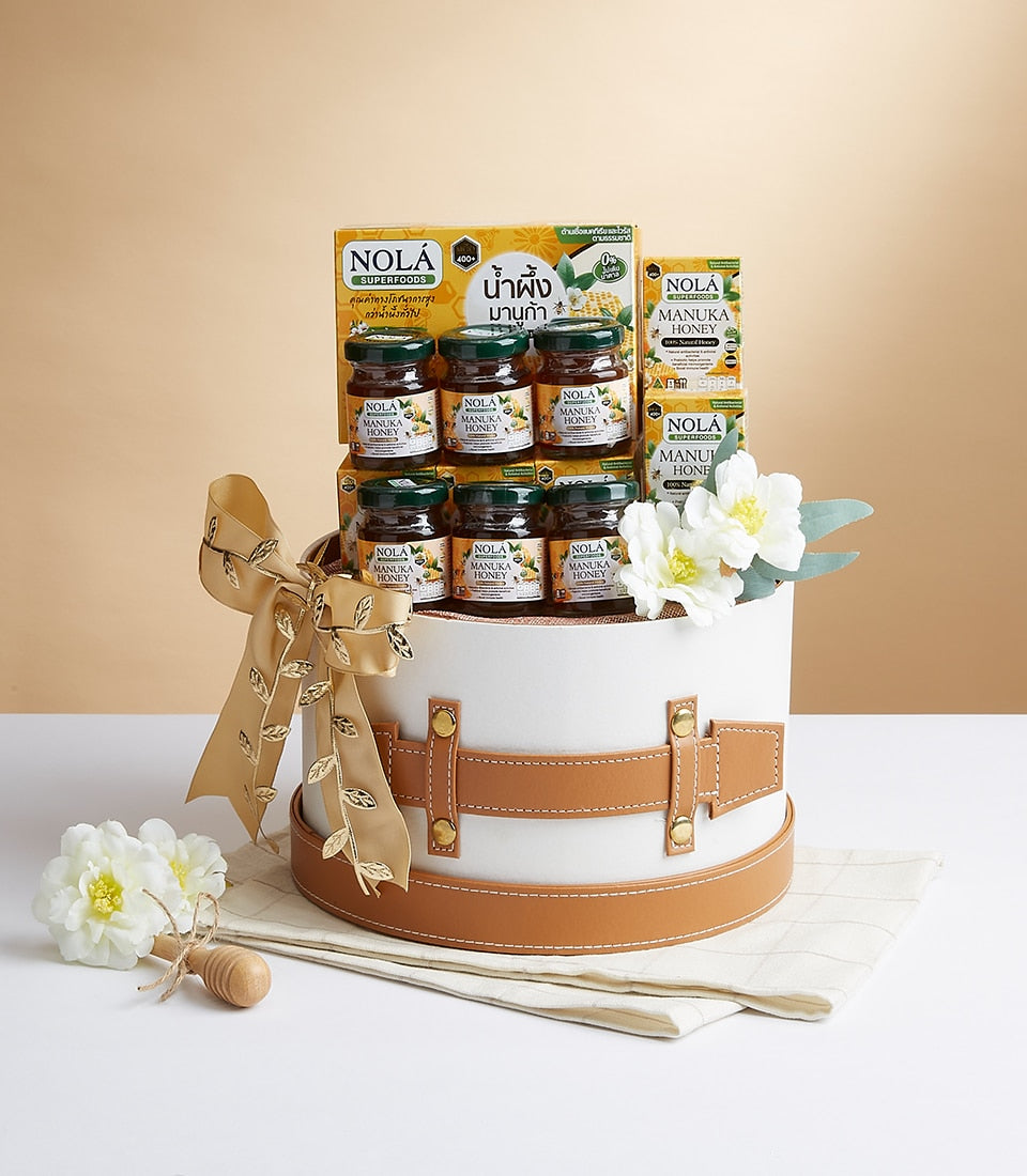 Nola Manuka Honey gift box with six jars, superfoods boxes, gold ribbon and white flowers in premium round presentation box