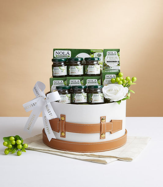 Nola Fiber Green wellness gift basket with white cylindrical box, tan leather strap, and green superfood jars