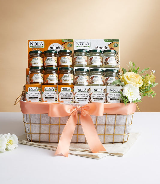 Gold wire gift basket with peach ribbon bow filled with Nola Superfoods wellness supplements and fresh-style flowers