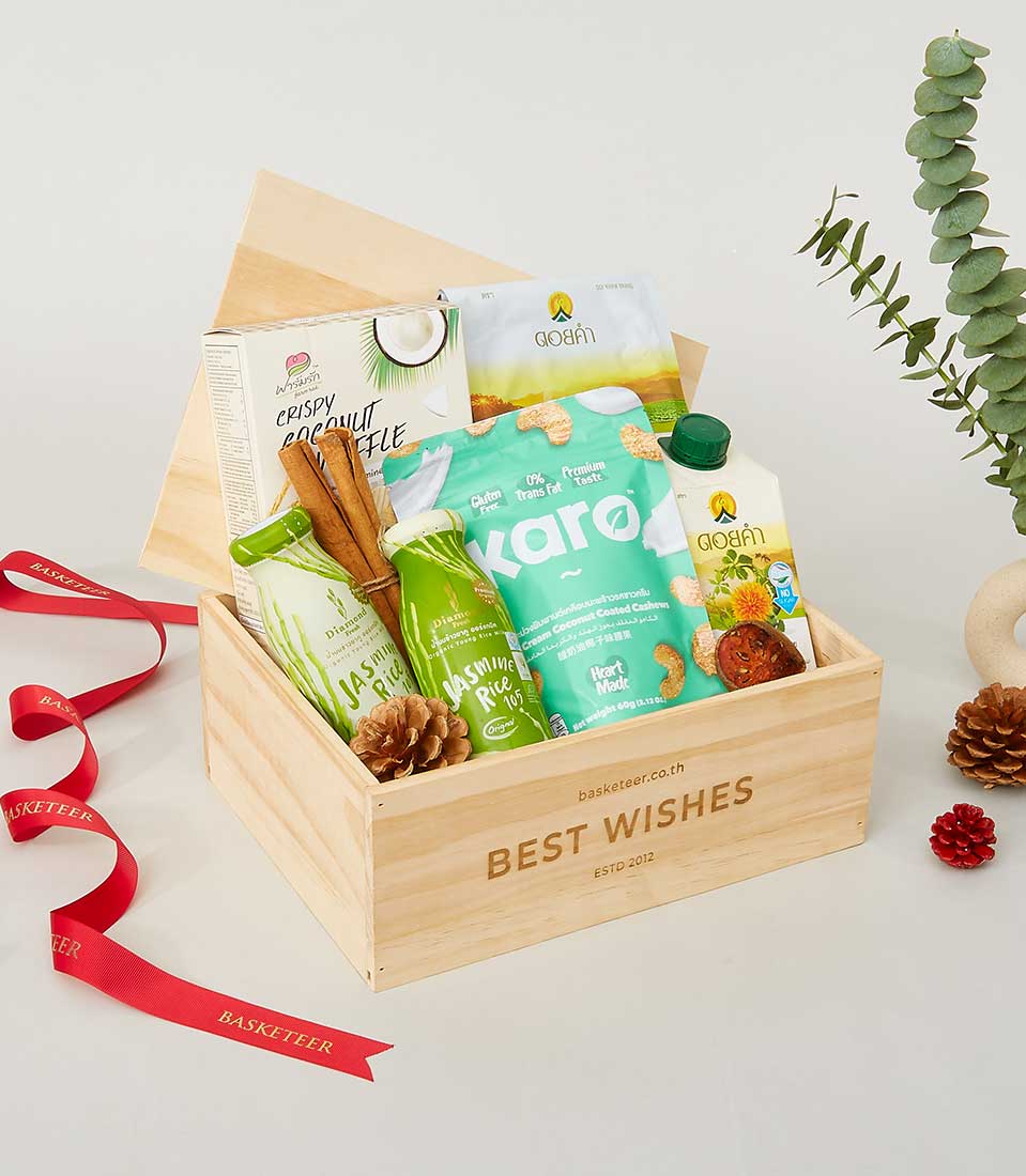 Wooden gift box filled with gourmet treats, jasmine rice, coconut, and artisan goods with cinnamon sticks, perfect for New