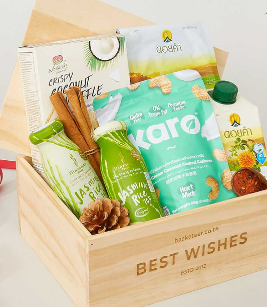Wooden gift box with gourmet treats including crispy coconut waffle, cashews, and jasmine rice drink for New Year gifting
