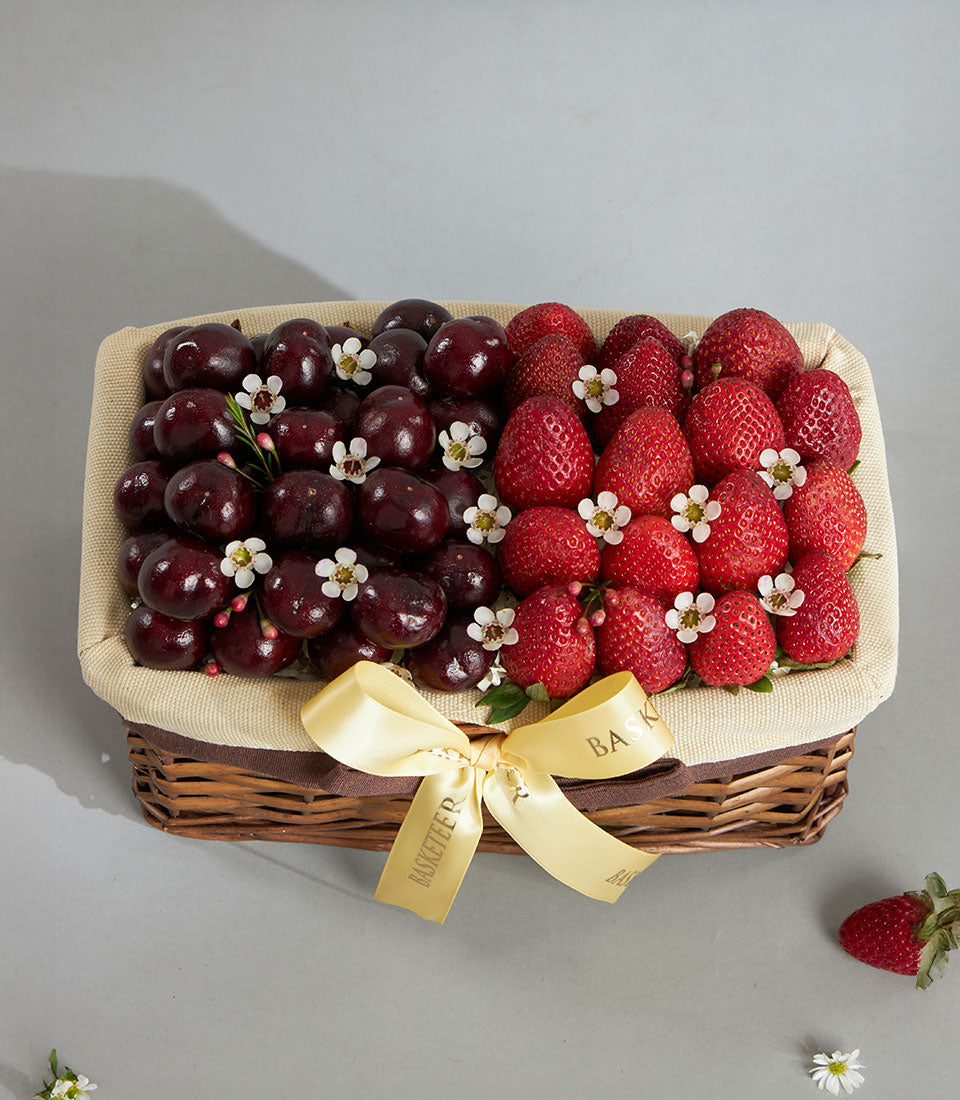 Premium cherry and strawberry gift basket with white flowers and gold satin bow