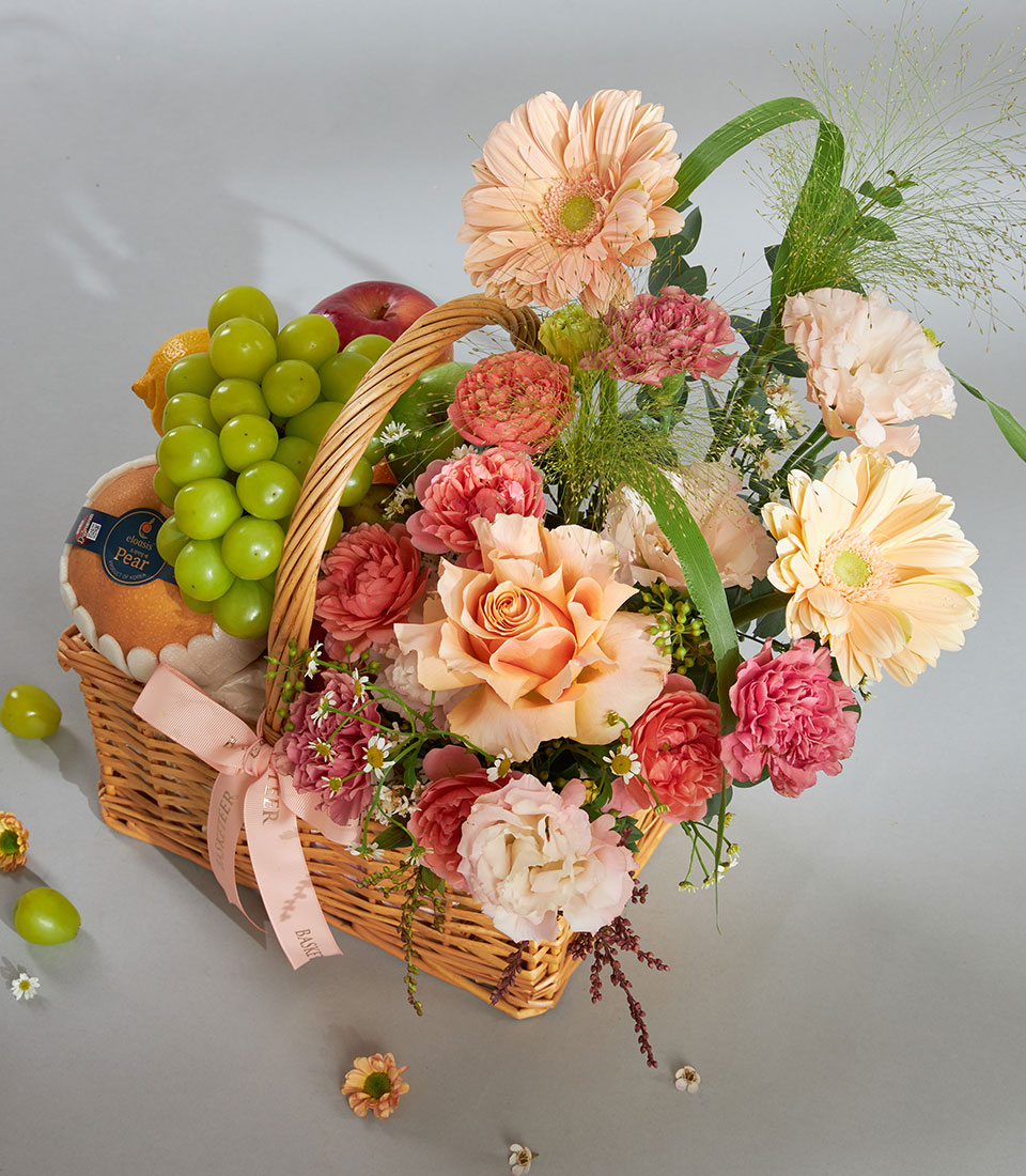 Peach and pink fruit and flower gift basket with gerbera daisies, roses, and fresh fruit for birthday