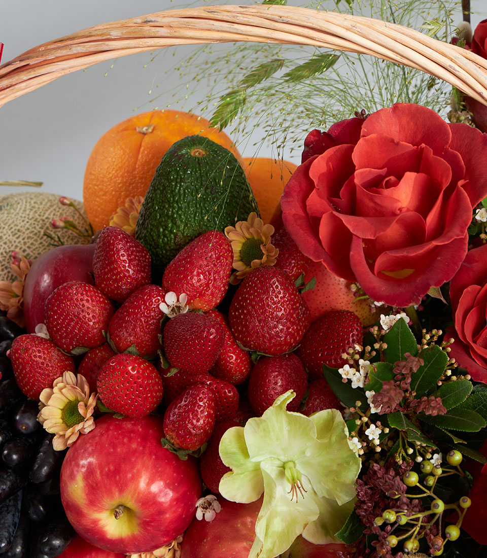 Basketeer premium hamper delivery Thailand. Fresh strawberries, apples, oranges and roses in a woven wicker fruit gift basket.