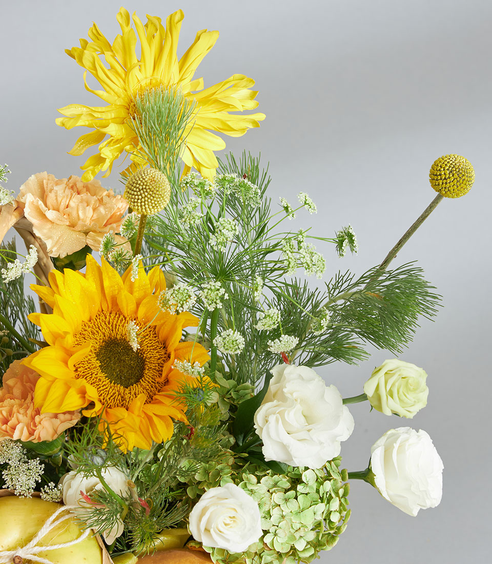 Bright yellow premium fruit and floral basket with sunflower, gerbera daisy, roses, and green apples