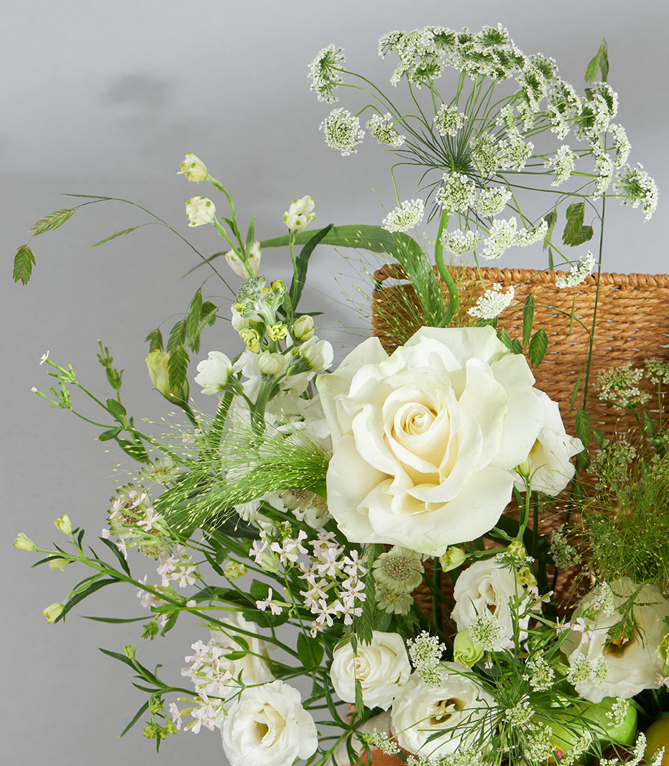 Elegant white and green luxury fruit floral basket with roses, lisianthus, and fresh citrus accents