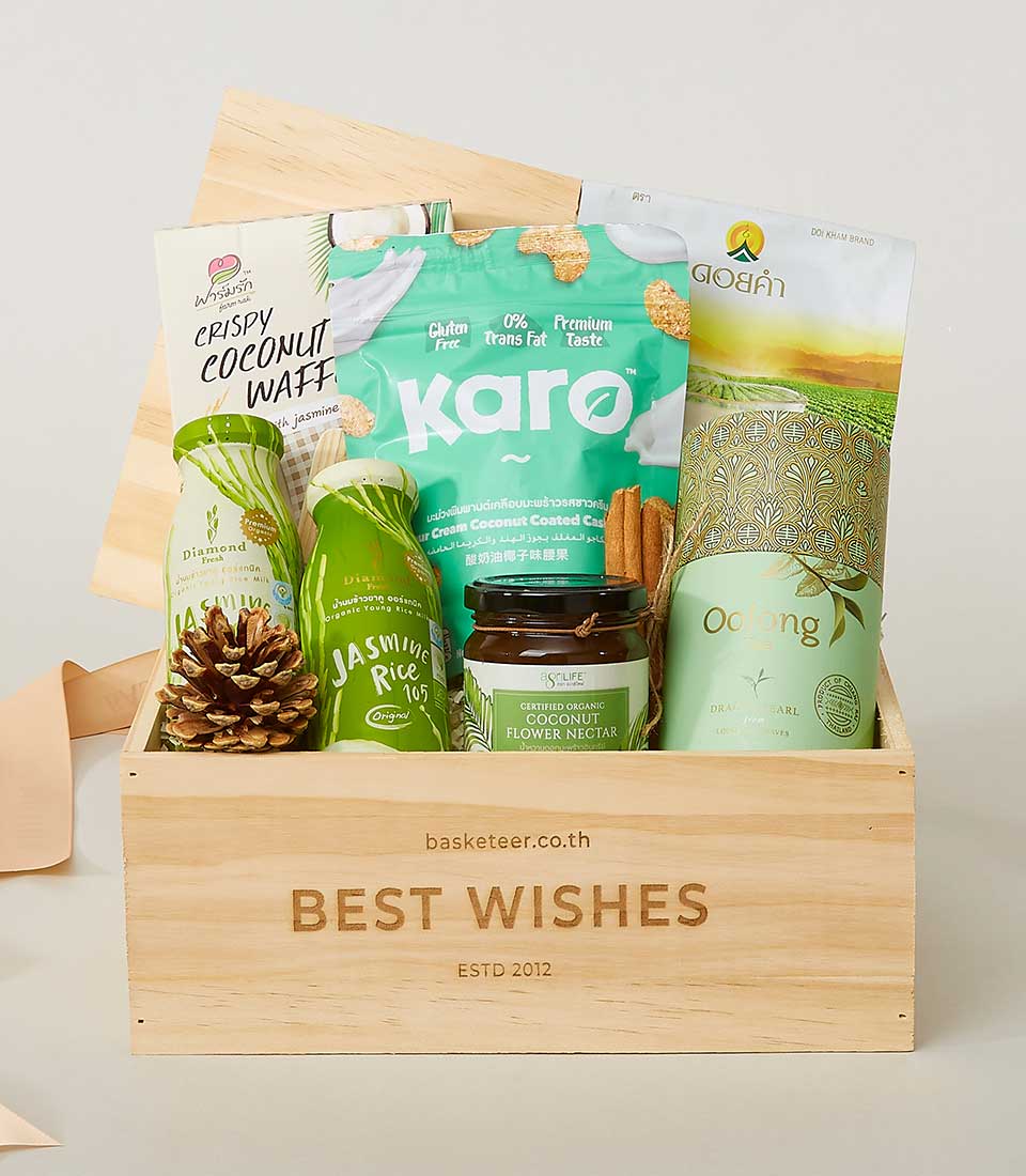 Wooden gift box filled with jasmine rice drinks, organic coconut nectar, gluten-free snacks, coconut wafers, and oolong tea
