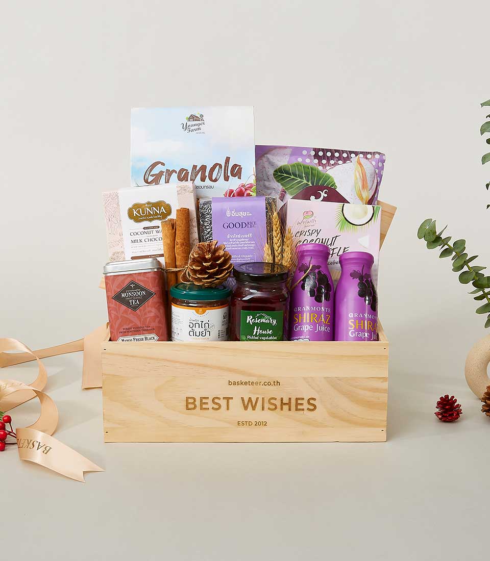 Premium wellness gift box with granola, tea, grape juice, and artisan preserves in wooden crate for New Year