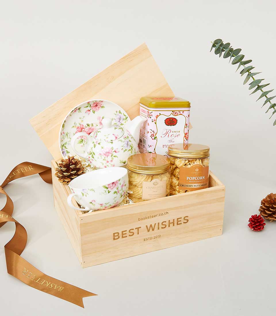 Luxury New Year gift crate with floral teapot, rose tea, gourmet cookies, and caramel popcorn