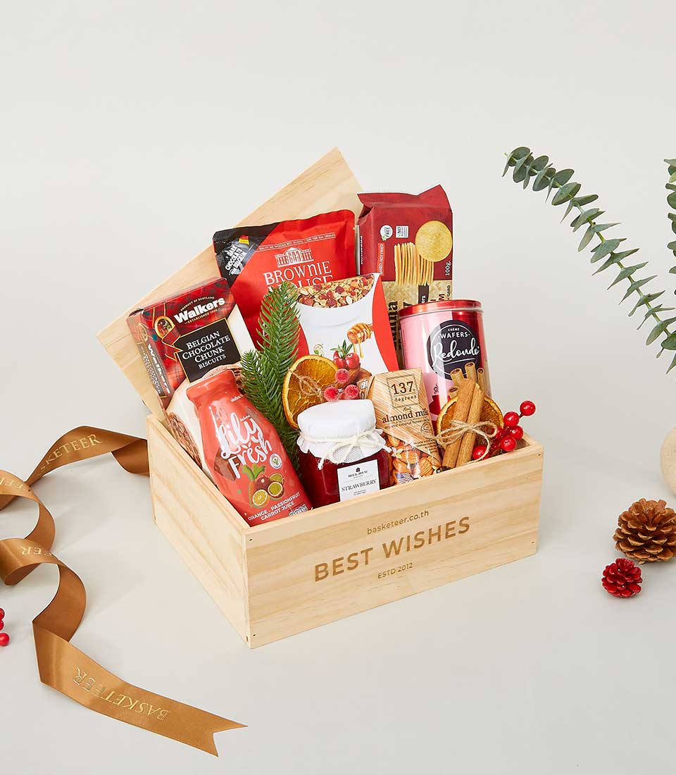 Wooden New Year gift crate with gourmet treats, chocolate biscuits, jam, and festive holiday garnish