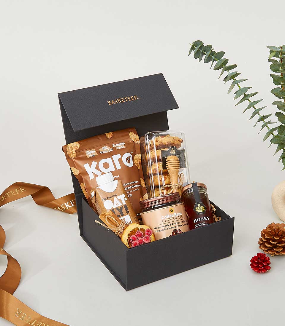 Luxury gourmet gift box with roasted cashews, cookies, coffee chocolate, and honey for New Year celebrations
