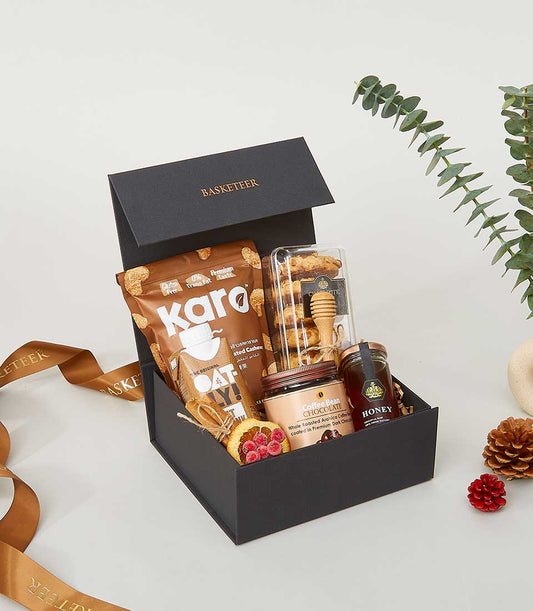Luxury gourmet gift box with roasted cashews, cookies, coffee chocolate, and honey for New Year celebrations