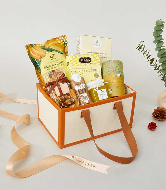 Premium New Year gourmet gift box with banana chips, coconut waffle, oolong tea, and artisan snacks