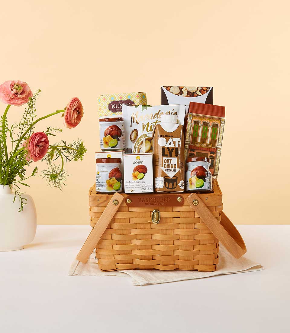 Bountiful Health Collection gift basket with wellness foods, pink ranunculus flowers, and artisan preserves in woven basket