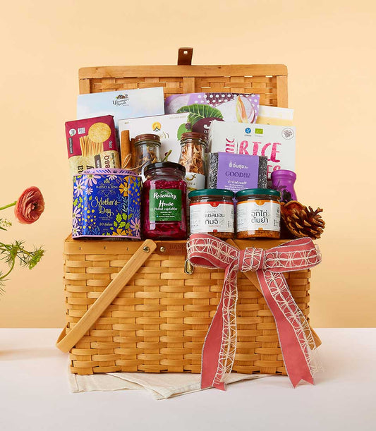 Luxury gourmet gift hamper with jars of pickled vegetables, kimchi, and specialty foods in woven wicker basket with red