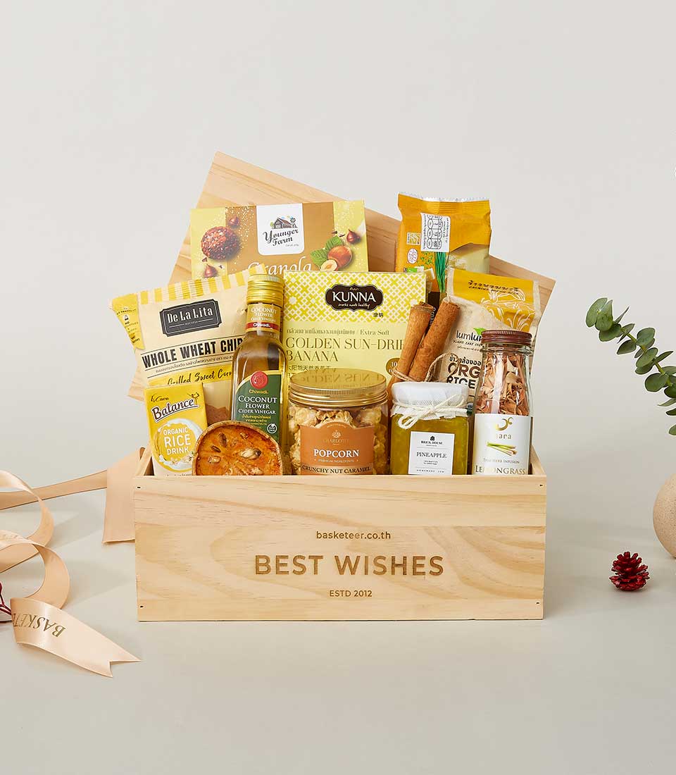 Light wooden crate wellness gift hamper with gourmet snacks, coconut vinegar, and jam for New Year