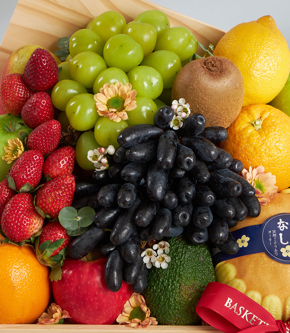 Premium wooden crate with fresh grapes, strawberries, apples, citrus and seasonal fruits, artisan gift hamper
