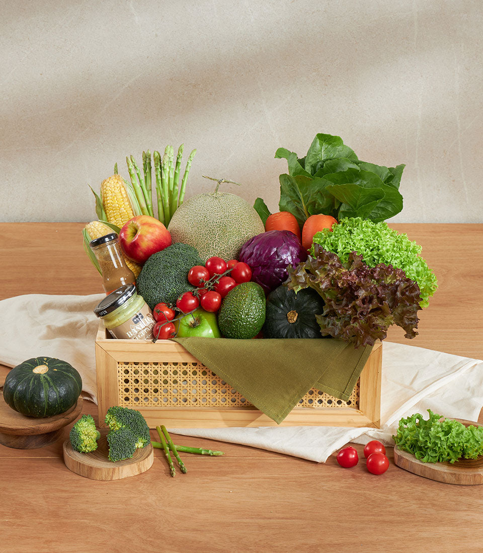 Fresh produce gift crate with organic vegetables, fruits, and artisan spreads in woven rattan wooden basket