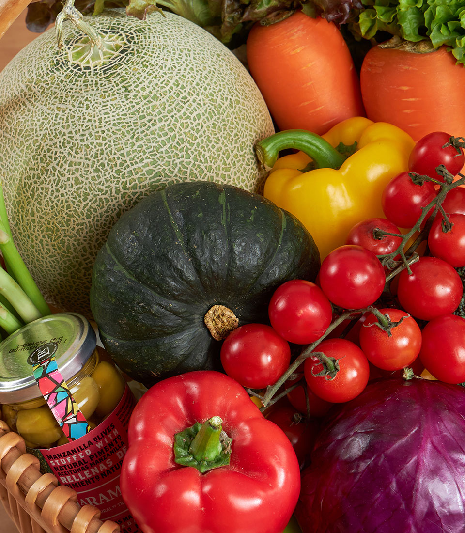 Premium fresh vegetable and gourmet basket with cantaloupe, squash, bell peppers, tomatoes, carrots, cabbage, asparagus, and