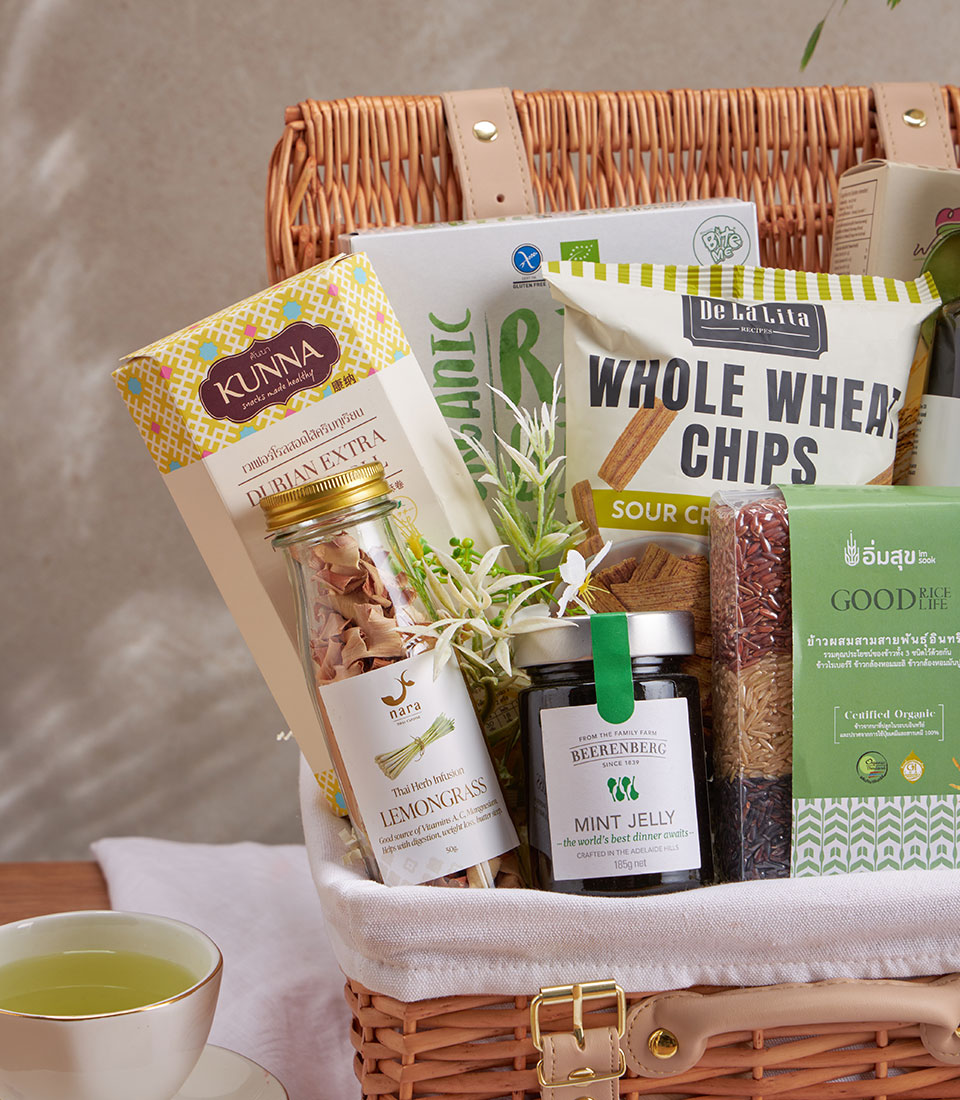Wicker gift basket with premium gourmet snacks, organic rice, olive oil, and herbal infusions for wellness gifting