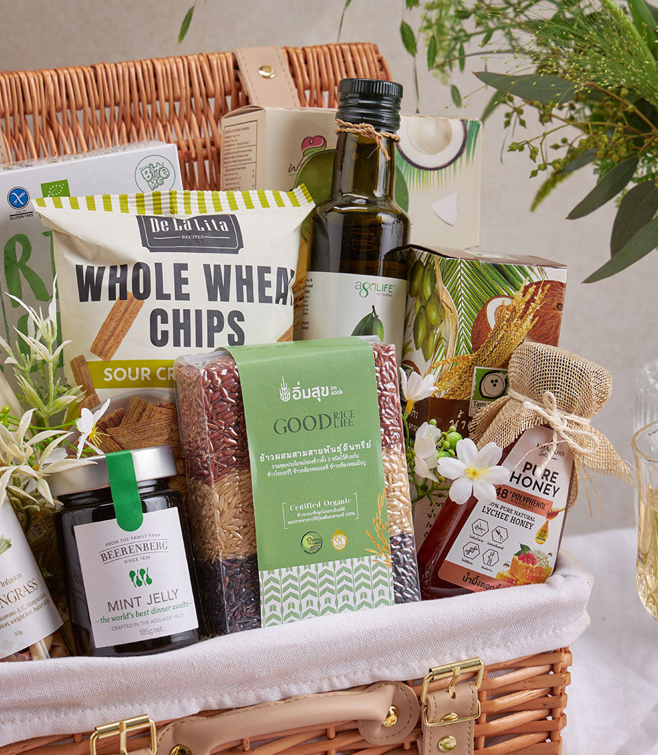 Premium wellness gift basket with gourmet rice, olive oil, honey, and whole wheat chips in woven wicker