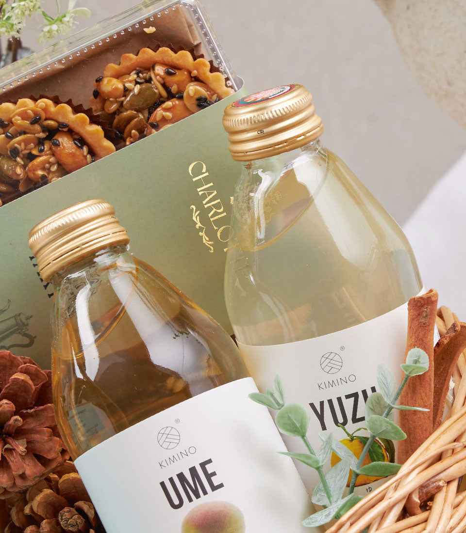 Premium gift hamper with sparkling beverages, nut tarts, and artisan wellness selections in woven basket
