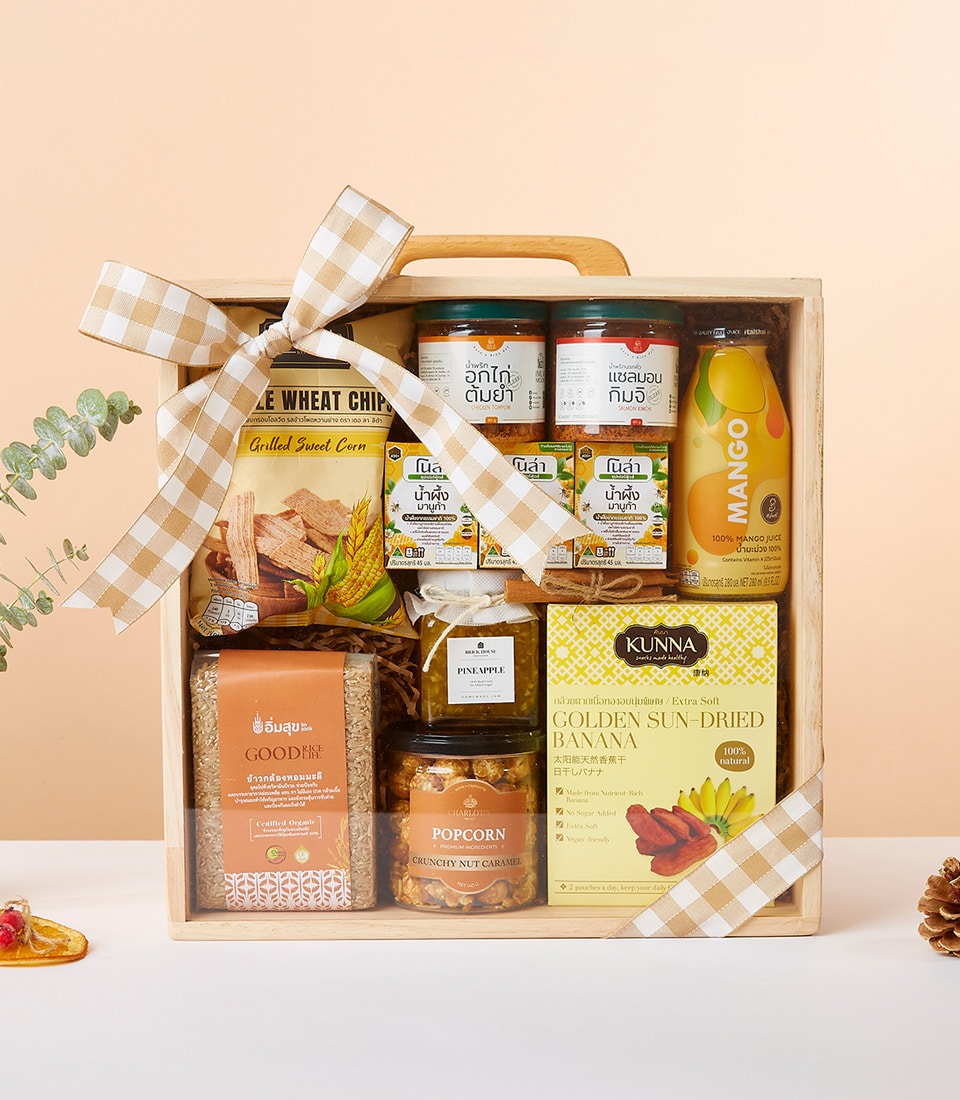 Wooden gift box filled with gourmet snacks, chili pastes, honey, and artisan treats tied with checkered ribbon