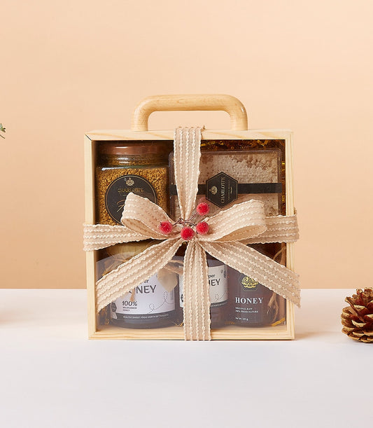 Honeycomb Harmony gift box with bee pollen, raw honey, and honeycomb in light wood with beige ribbon