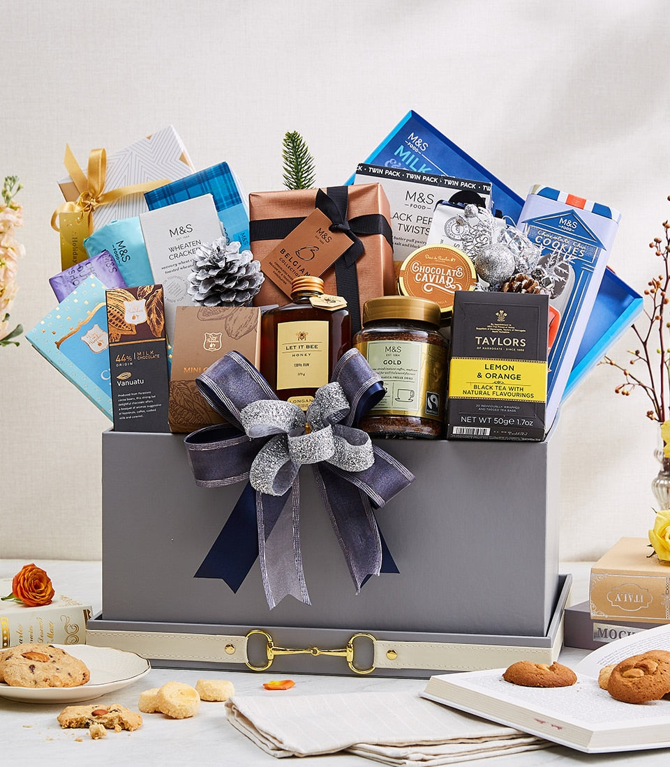 Luxury grey gift hamper with dark blue and silver ribbon bow, filled with gourmet chocolates, honey, coffee, tea, and
