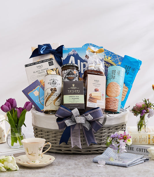 Luxury gourmet gift basket with dark blue ribbon, grey wicker design, filled with international delicacies and tea for New