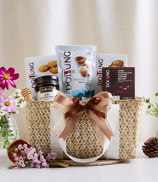 Woven straw gift basket with macadamia nuts, dark chocolate coffee beans, macadamia honey, gold and brown ribbon bow,