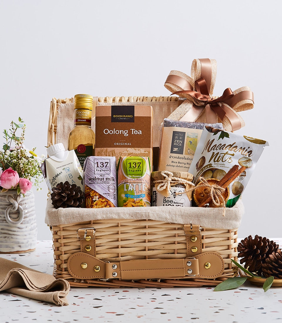 Flavors of Thailand wicker gift basket with coconut syrup, oolong tea, plant-based milk, macadamia nuts, honey, and dried