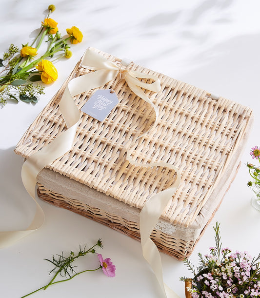 Premium wicker tea hamper with cream satin ribbon and floral arrangement, New Year gift presentation