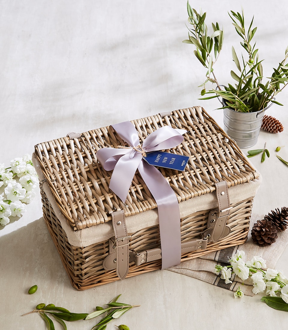 Wicker hamper with light purple ribbon and fresh florals for New Year gifting