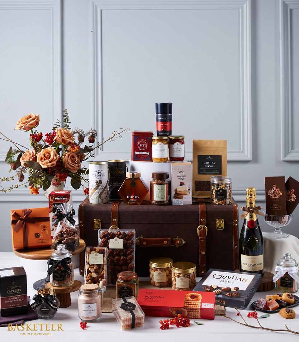Luxury Moët champagne gift hamper with gourmet preserves, chocolates, and fresh roses in leather trunk