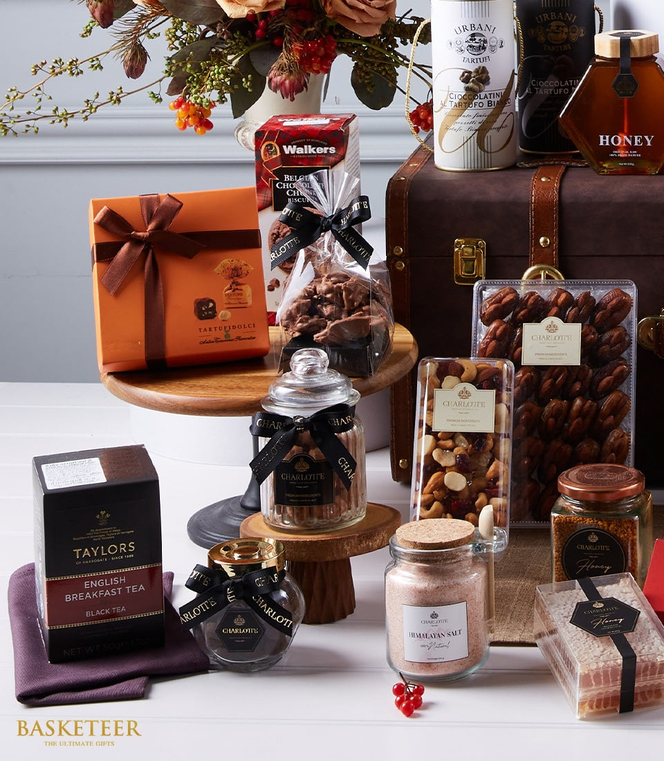 Luxury Moët Champagne and gourmet hamper with chocolates, biscuits, tea, and artisan treats in brown leather trunk