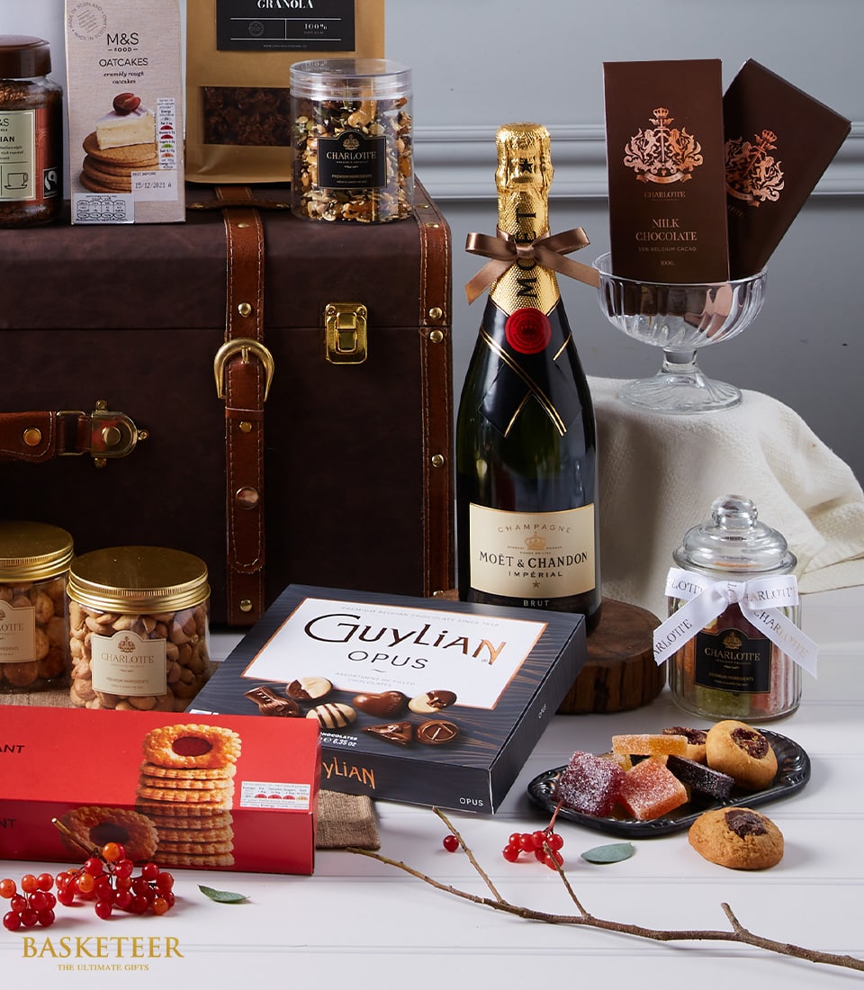 Luxury Moët Champagne gift hamper with gourmet chocolates, nuts, and artisan treats in leather trunk