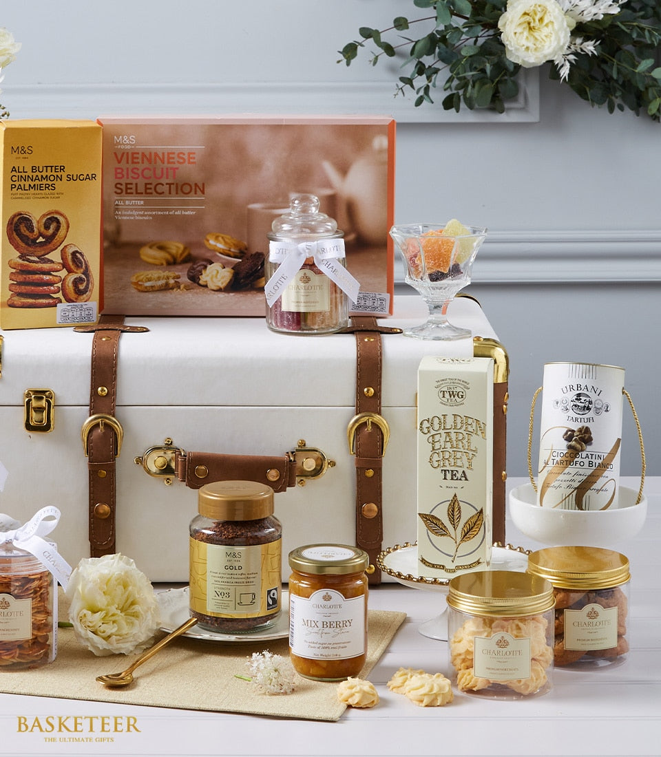 Luxury Worldly Treats hamper with gourmet biscuits, Earl Grey tea, truffles, jam, and candies in white leather trunk
